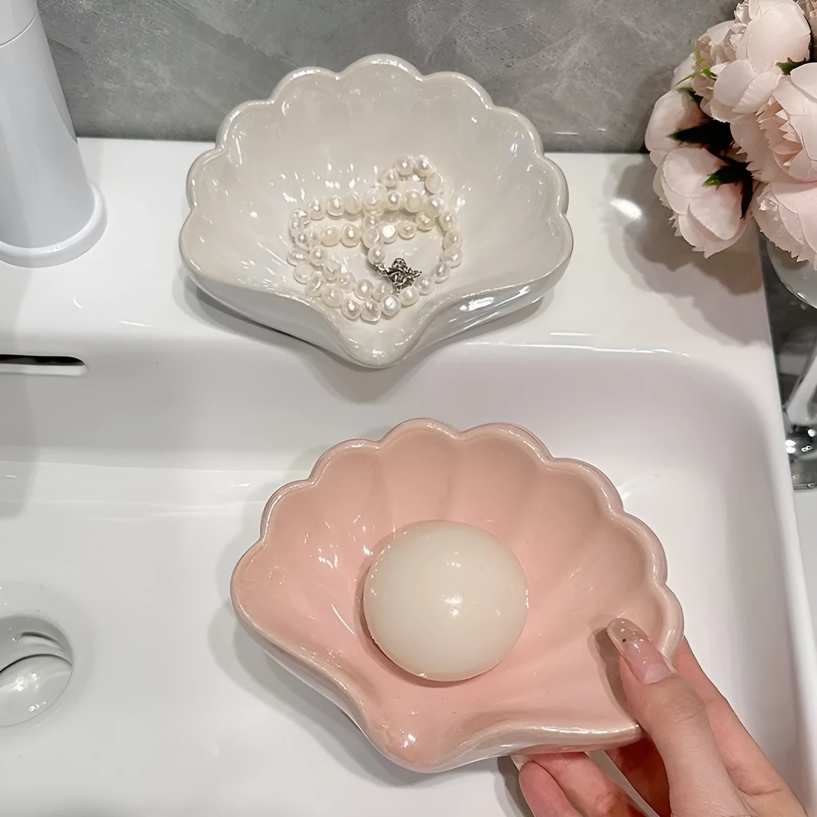 Plastic shell-shaped soap dish in pearl white or cherry blossom pink for bathroom organisation