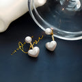 Women's heart-shaped stud earrings with a pearl-like centre in electroplated alloy, Korean style.