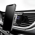 Black car phone holder mounted on car air vent with smartphone secured in adjustable clamp