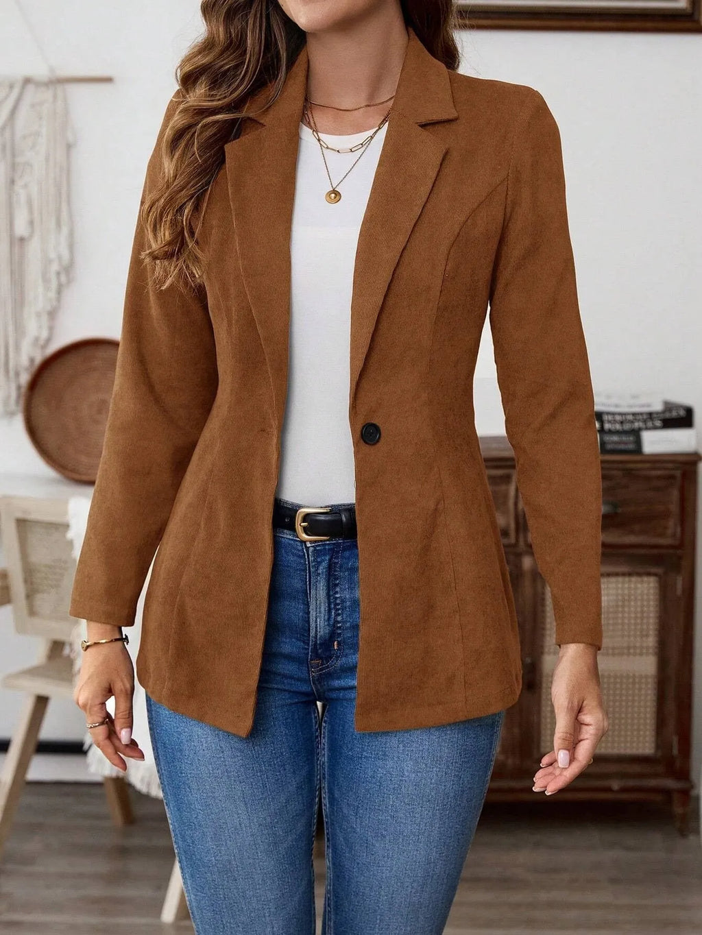 Brown single-breasted leisure blazer with lapel collar and long sleeves on a hanger.