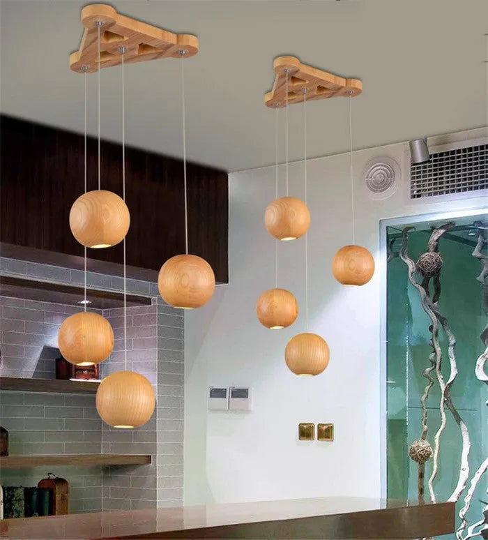 Nordic style solid wood ball chandelier pendant light hanging from ceiling on adjustable cord.