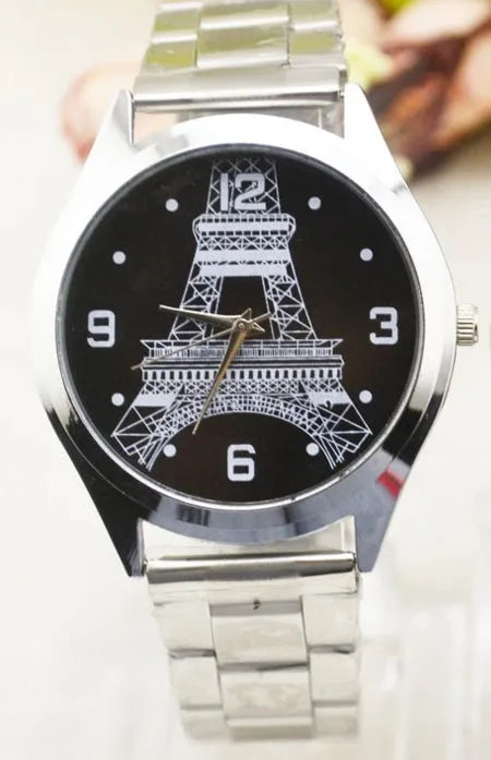 Eiffel Tower themed wrist watch with stainless steel mesh strap on an adult wrist.