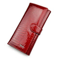 Women's patent leather purse with crocodile pattern in red colour showing pigskin lining interior