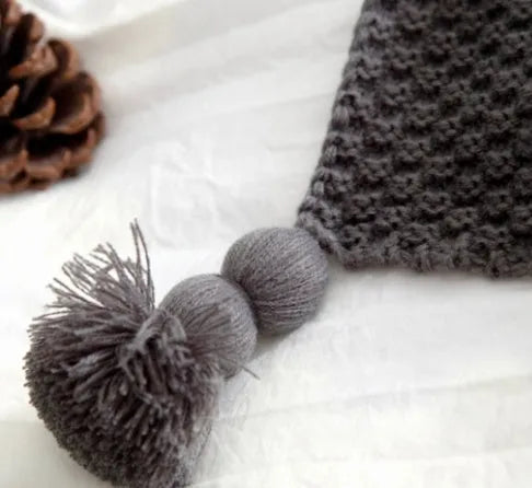 Nordic-style fringed knit acrylic blanket in a plain pattern, shown in a neutral colour on a sofa.