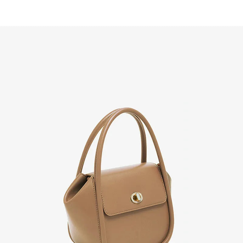 Wing-shaped women's leather handbag with latch closure and cross-body strap in available colours.