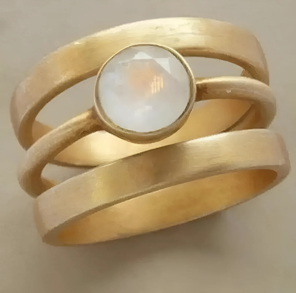 Gold geometric hollow ring with white chalcedony stone on a titanium steel band.