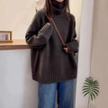 Women's loose black turtleneck sweater with a thick curling pile collar, casual style.