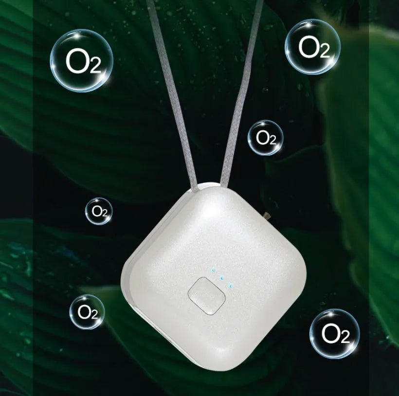Small pink wearable USB air purifier necklace on a person, showing compact size.