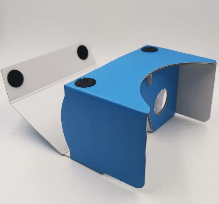 Foldable pink and white cardboard VR glasses headset with lenses and rubber head strap for smartphones.