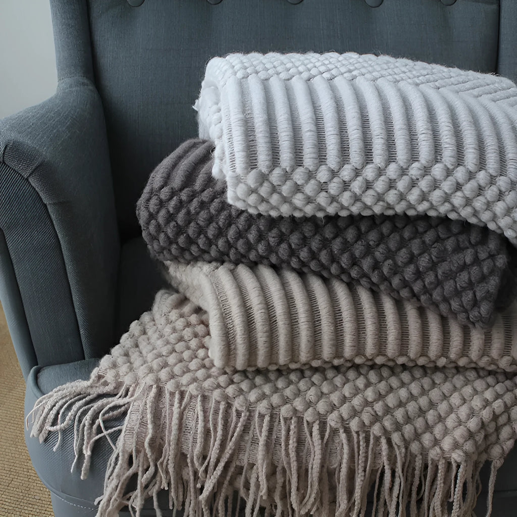 Small grey polyester fibre blanket folded to show its texture and colour.