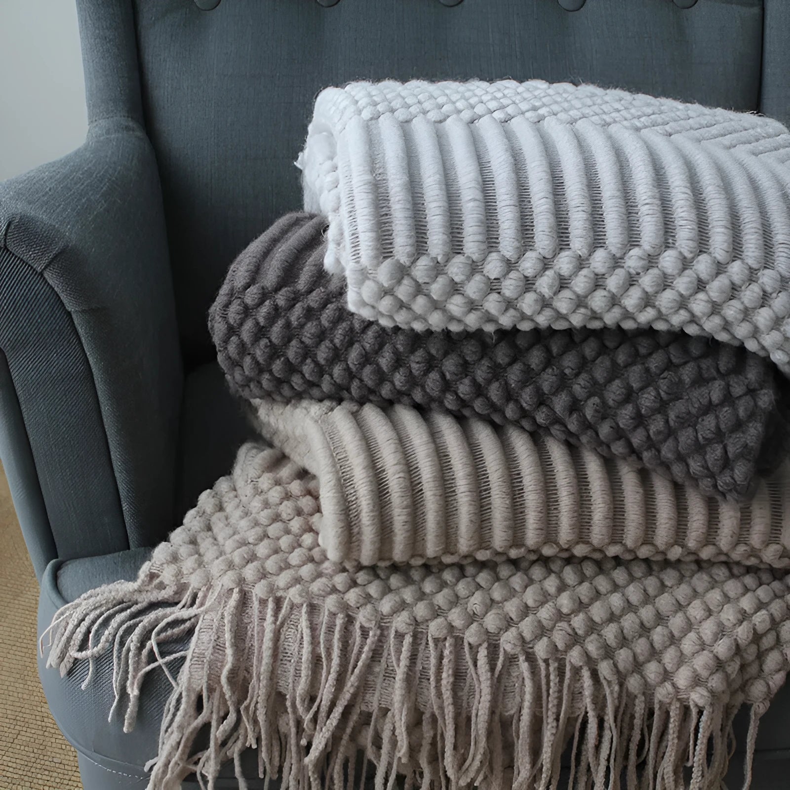 Small grey polyester fibre blanket folded to show its texture and colour.