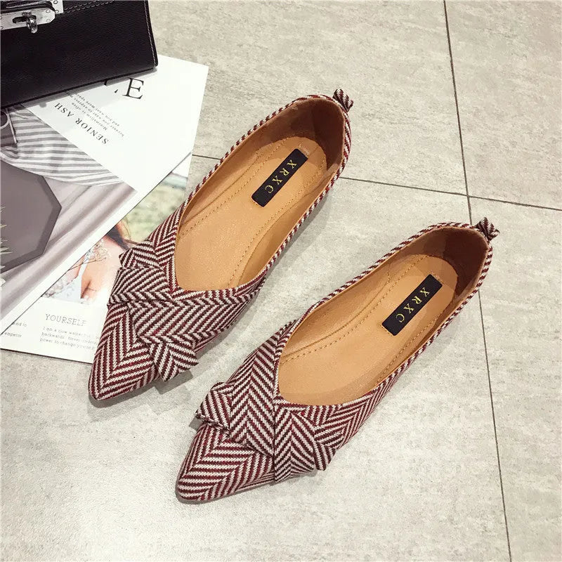 Women's red and black pointed-toe flat shoes with a low heel and cotton upper.