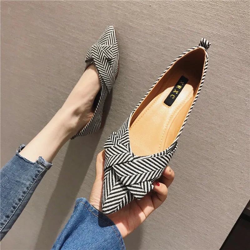 Women's red and black pointed-toe flat shoes with a low heel and cotton upper.