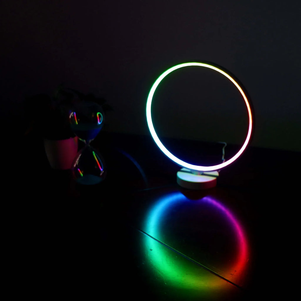 White Full Moon shaped table lamp with remote control on a wooden surface.