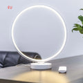 White Full Moon shaped table lamp with remote control on a wooden surface.