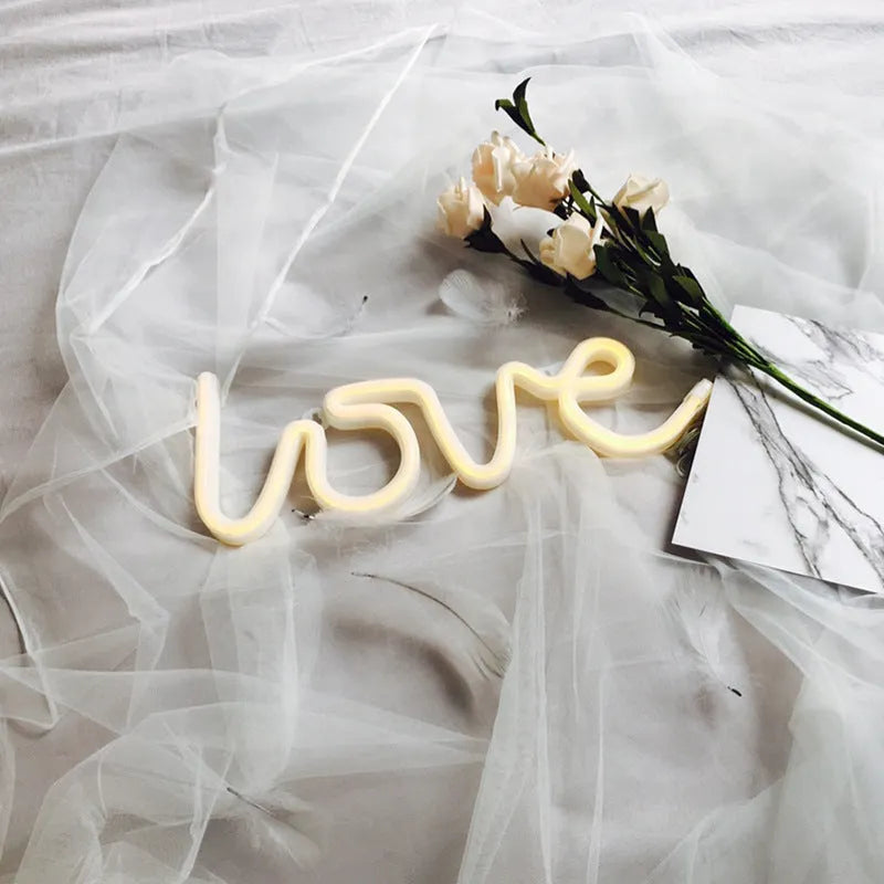 Love-shaped LED neon sign light with silicone shell in pink illumination on tabletop
