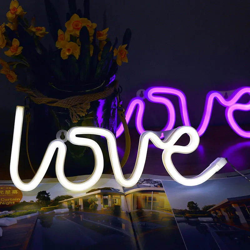 Love-shaped LED neon sign light with silicone shell in pink illumination on tabletop
