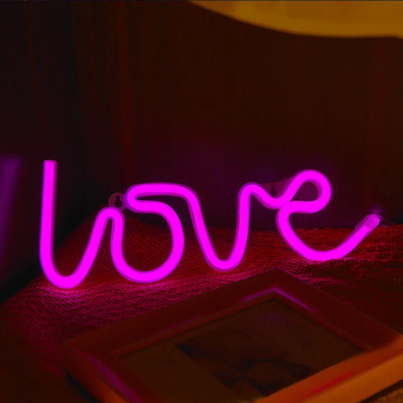 Love-shaped LED neon sign light with silicone shell in pink illumination on tabletop