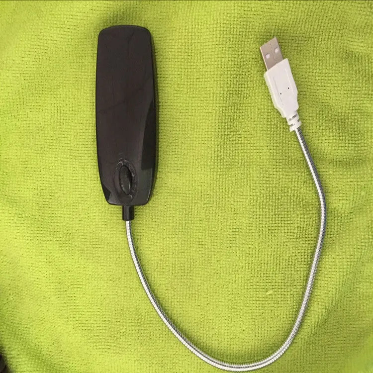 Black flexible gooseneck USB LED desk lamp bent over a book