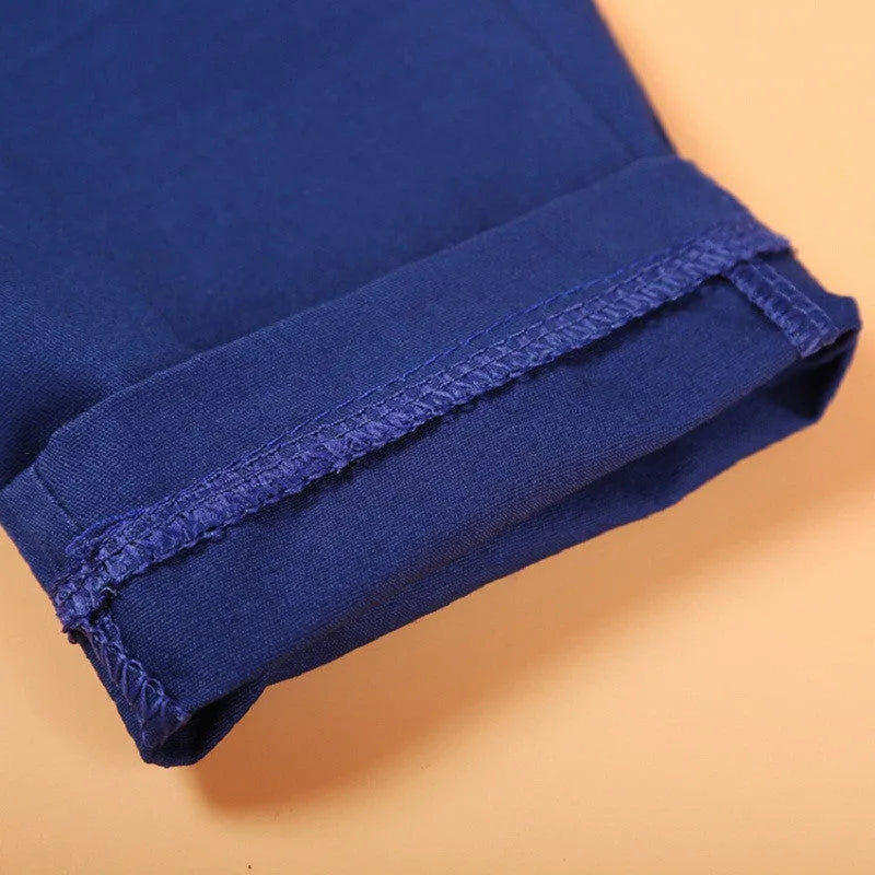 Blue boys' casual suit comprising a turtleneck, waistcoat, tie, and trousers on a hanger.