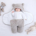 A baby quilted sleeping bag wrapper in a cotton blend fabric, shown in a light blue colour, laid flat.