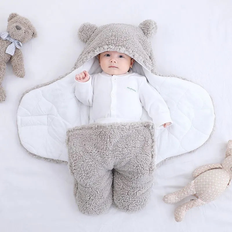 A baby quilted sleeping bag wrapper in a cotton blend fabric, shown in a light blue colour, laid flat.