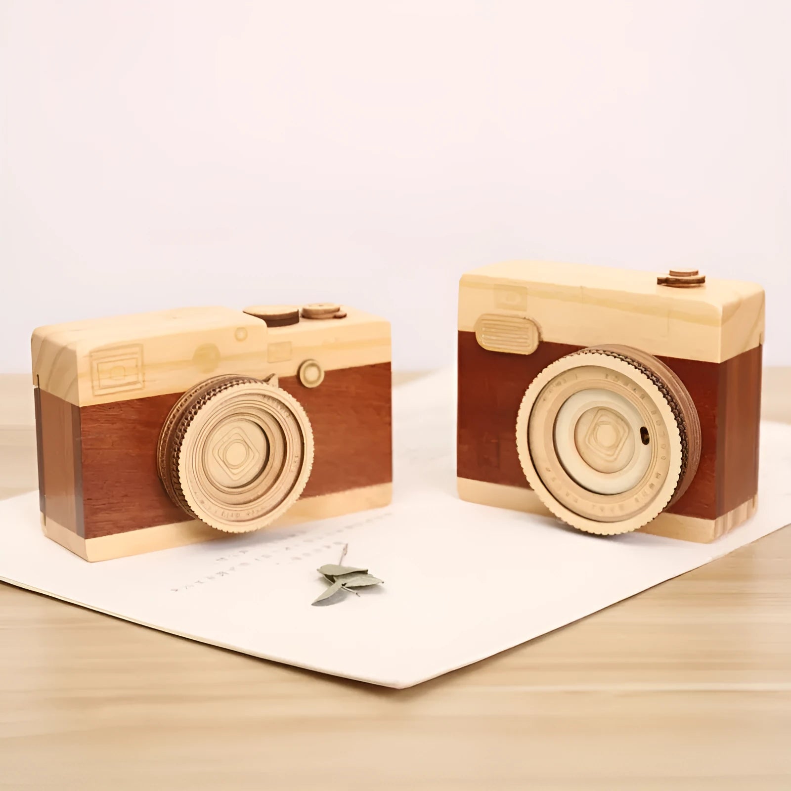 Pine wood camera-shaped music box with rotating mechanism on a wooden base.