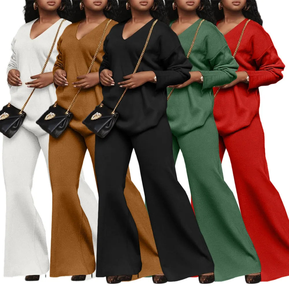 Women's brown suede two-piece suit with split sleeve top and full-length trousers on a model.