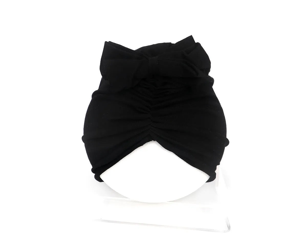 Soft acrylic knitted baby hat turban for infants and toddlers aged 0 to 28 months in a solid colour.
