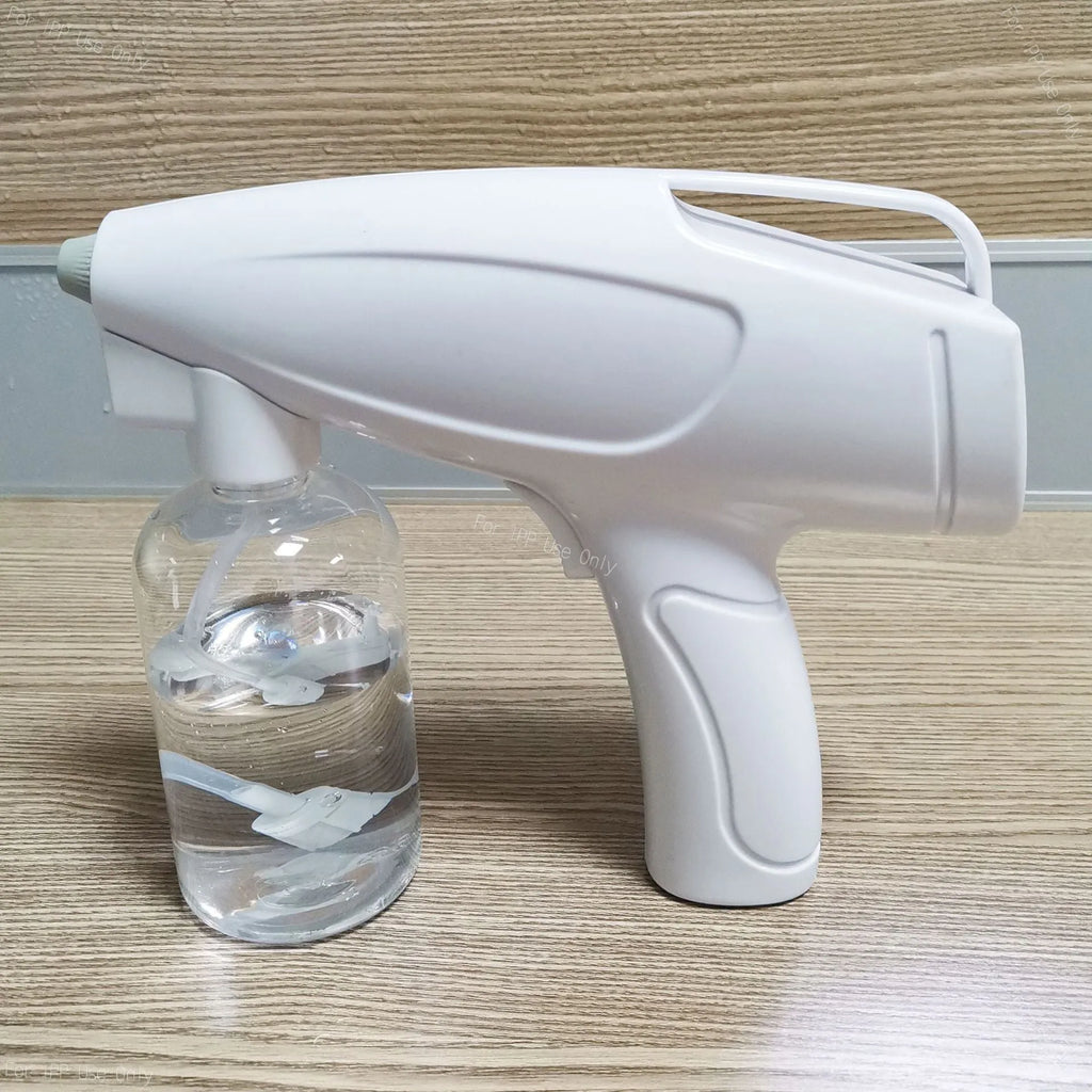 White handheld wireless electric spray disinfection gun with bottle and USB cable