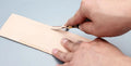 Leathercraft drum shovel edge shaver thinning knife with leather handle for wide edge sections.