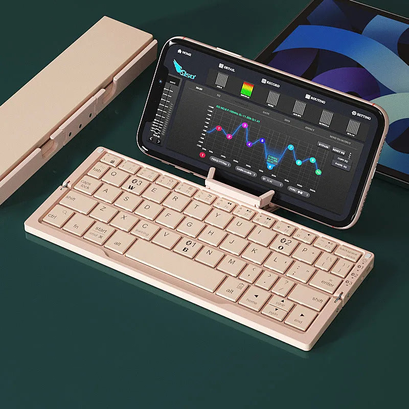 Silver white folding Bluetooth keyboard with stand holding a smartphone, showing compact folded size