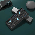 Silver white folding Bluetooth keyboard with stand holding a smartphone, showing compact folded size