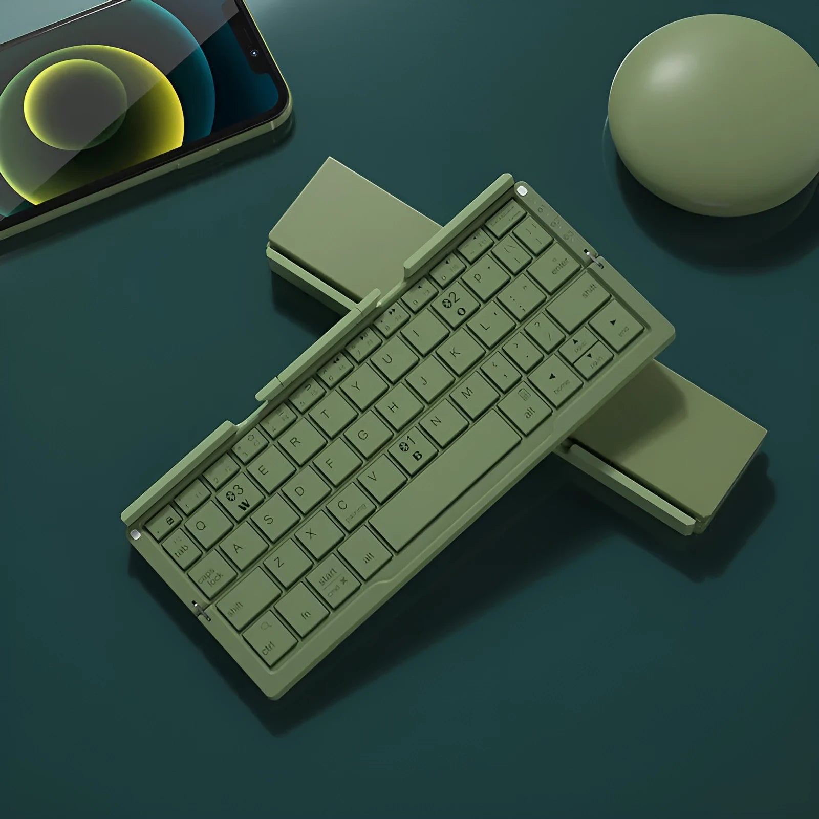 Silver white folding Bluetooth keyboard with stand holding a smartphone, showing compact folded size