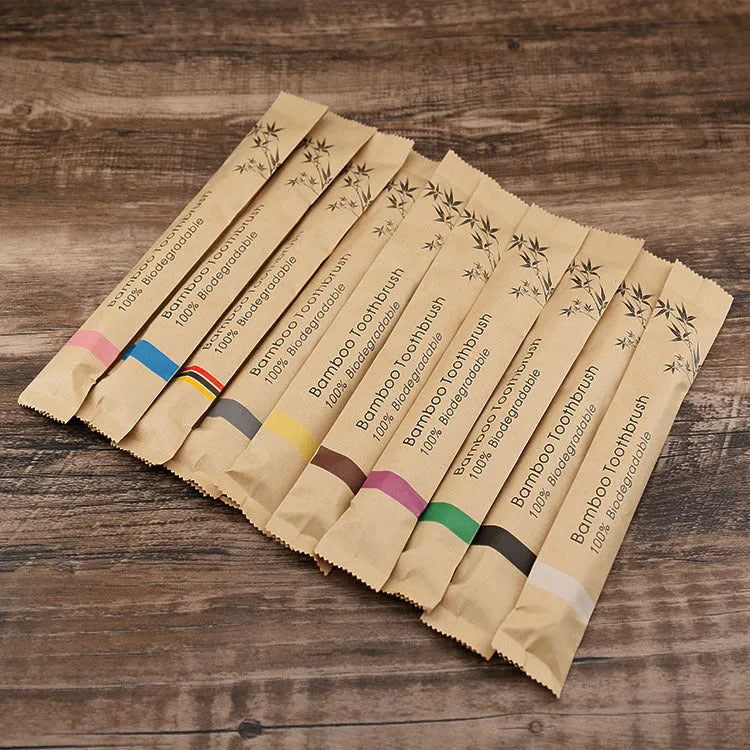 10 bamboo toothbrushes with coloured handles and charcoal bristles displayed together