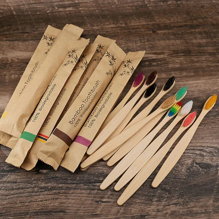 10 bamboo toothbrushes with coloured handles and charcoal bristles displayed together