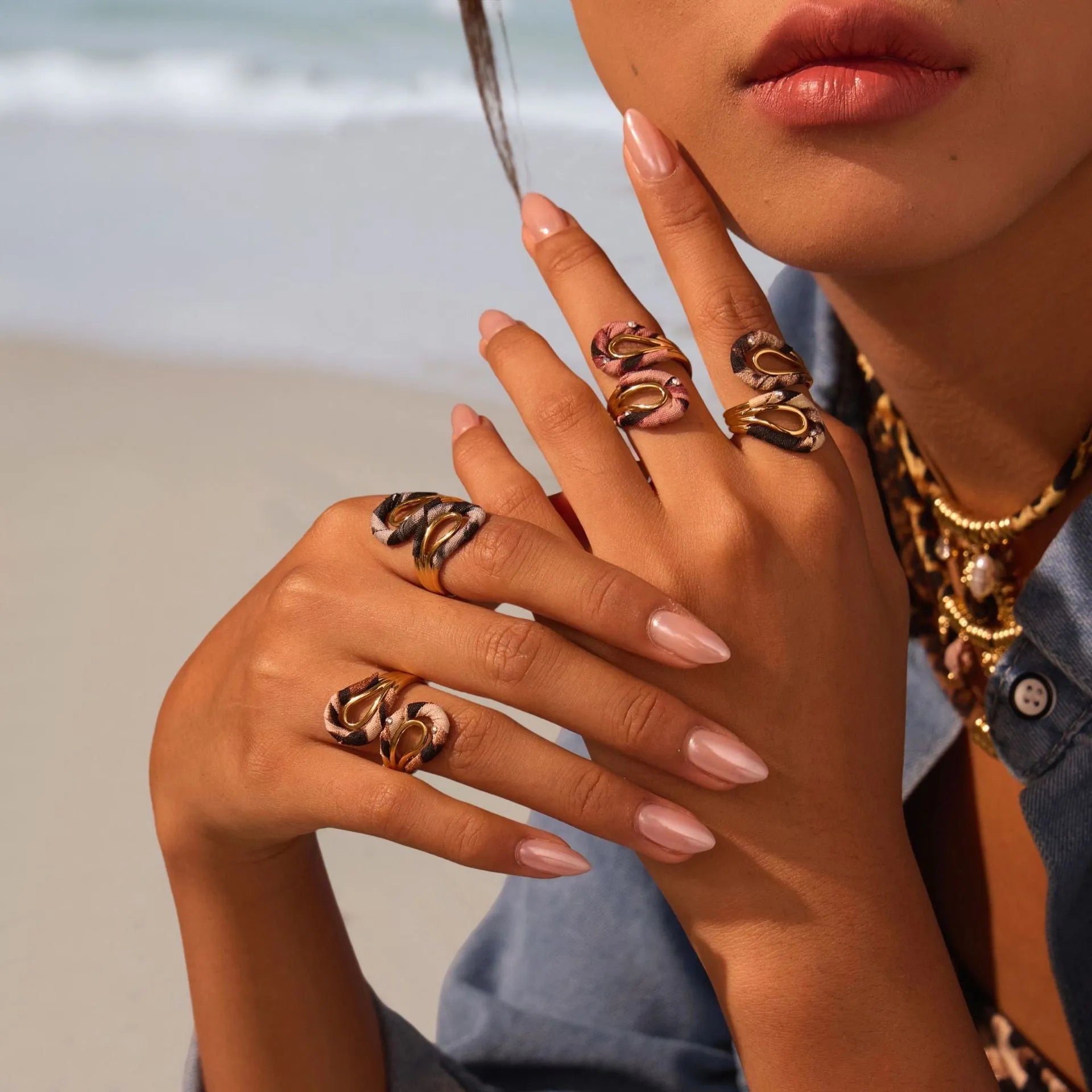Leopard print geometric open mouth ring on a finger, showing heart shape and adjustable stainless steel band.