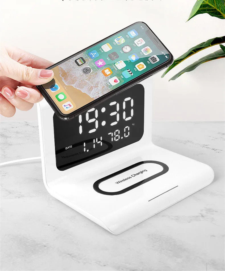 White wireless charger alarm clock showing time, calendar, temperature and humidity displays with charging surface