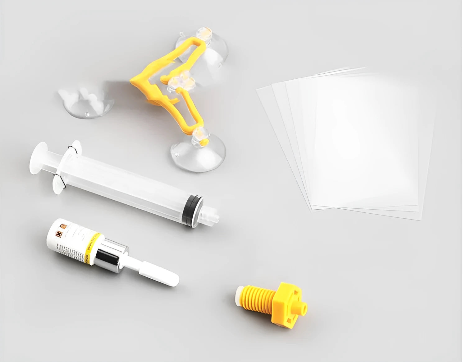 Yellow auto glass repair tool with triangle bracket and 2ML repair fluid on a car windshield