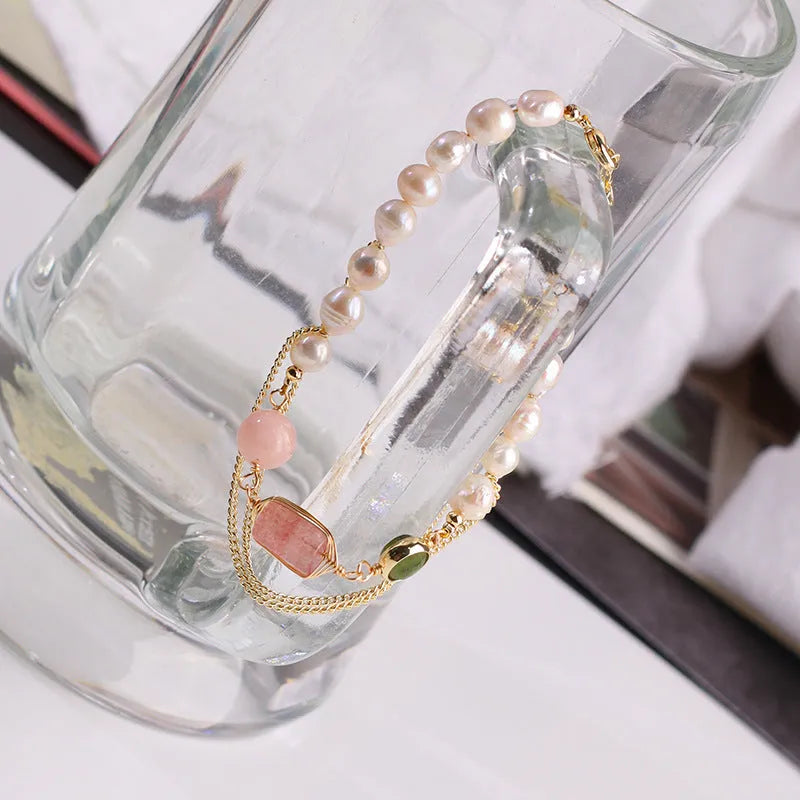 Women's pink freshwater pearl bracelet with geometric strawberry crystal charms on wrist