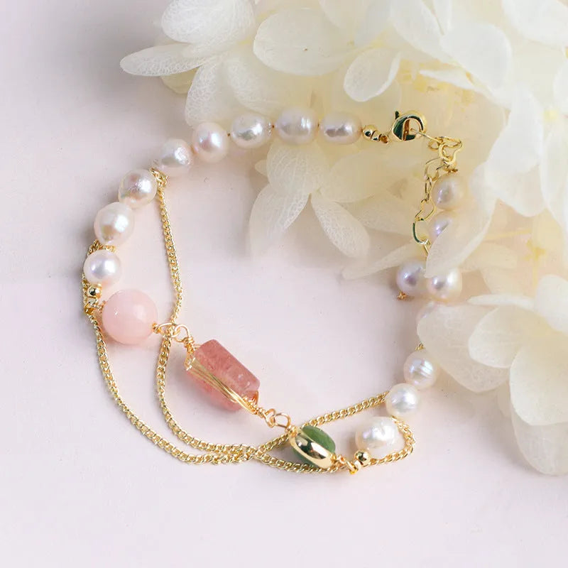 Women's pink freshwater pearl bracelet with geometric strawberry crystal charms on wrist