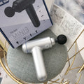 Cordless fascia massage gun with USB charging port in grey, red, or black colour options