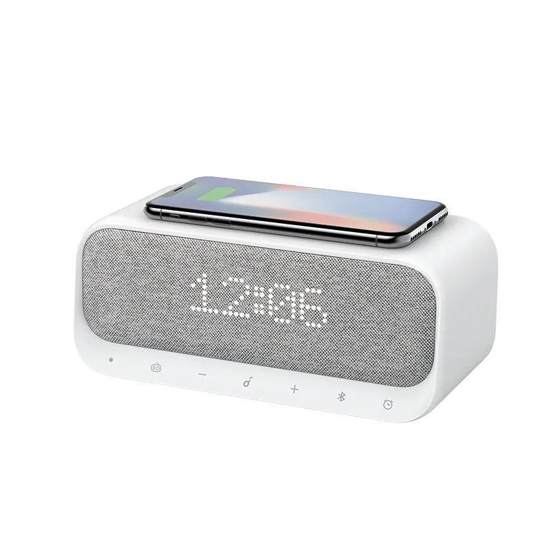 Anker Soundcore white wireless charging Bluetooth speaker and alarm clock on a bedside table.