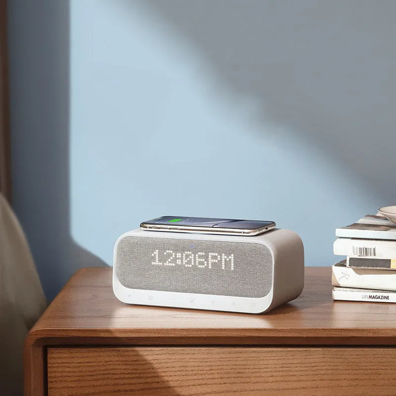 Anker Soundcore white wireless charging Bluetooth speaker and alarm clock on a bedside table.