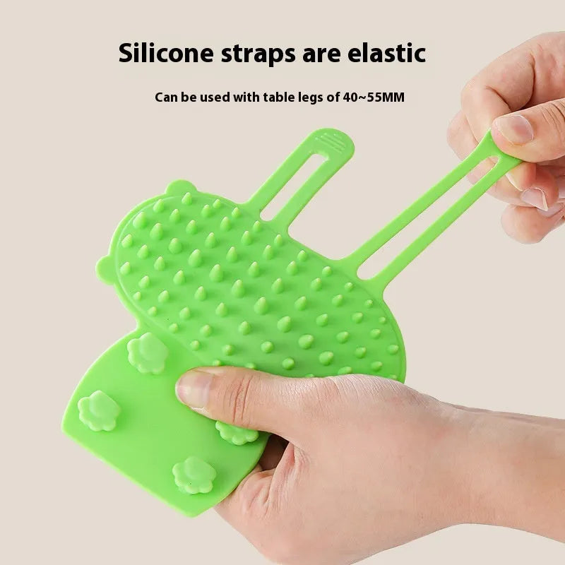 Silicone cat grooming comb with adjustable strap mounted on table leg
