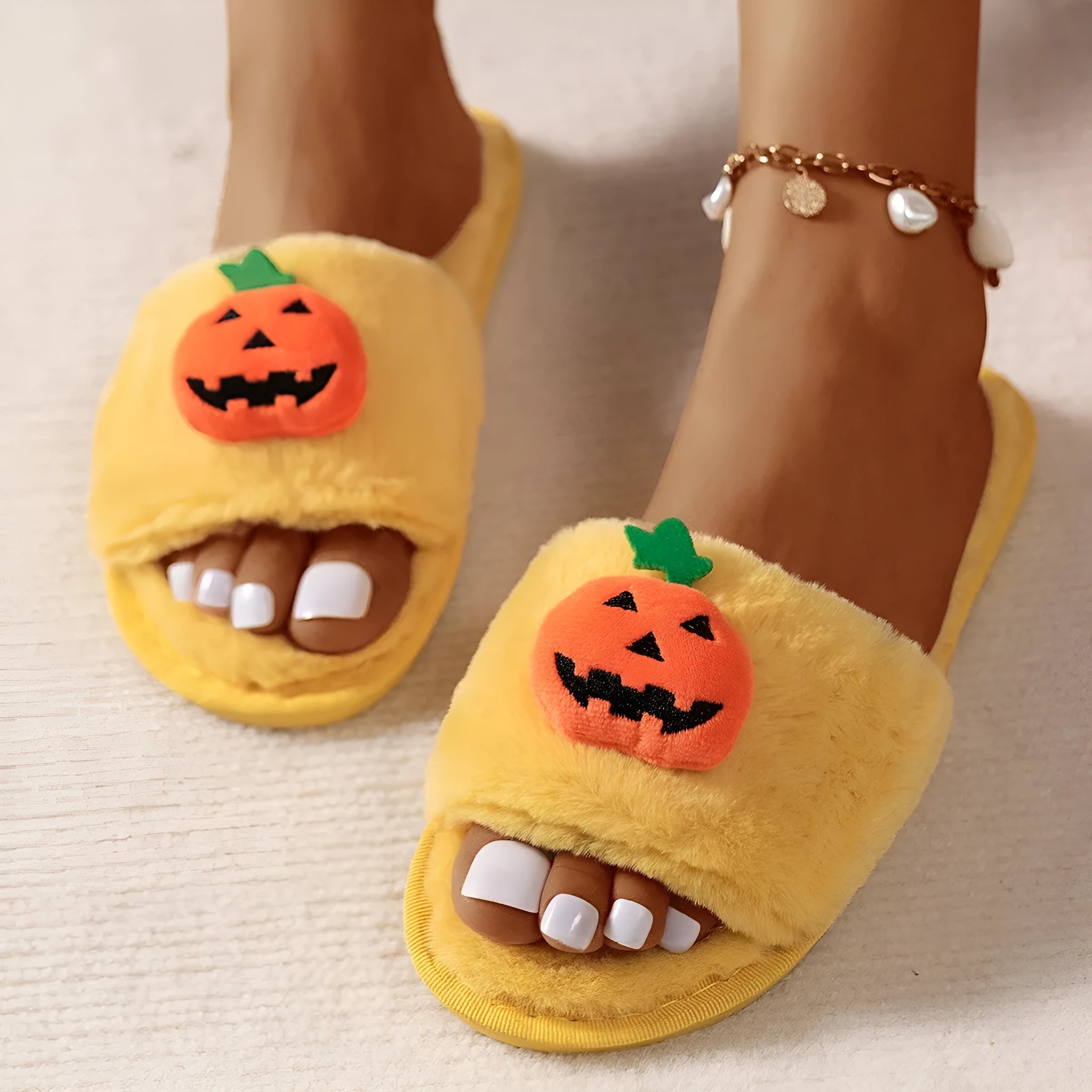 Yellow and white Halloween pumpkin cartoon design plush slippers with an open toe and textured sole.
