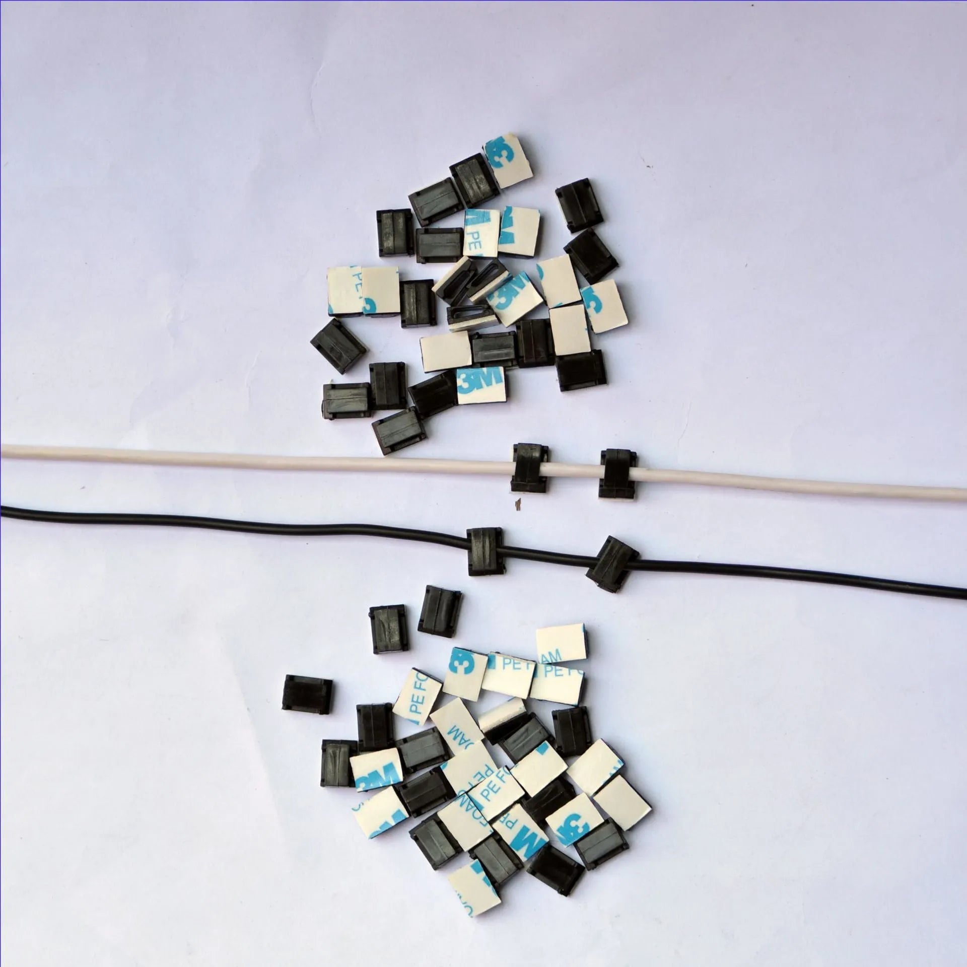 Black PA66 plastic wiring management clips for automotive and electronic cable organisation.