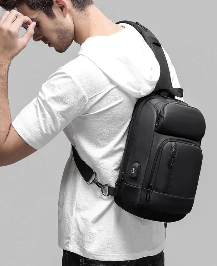 Black medium outdoor shoulder bag showing computer pocket, soft handle, and single air cushion strap.