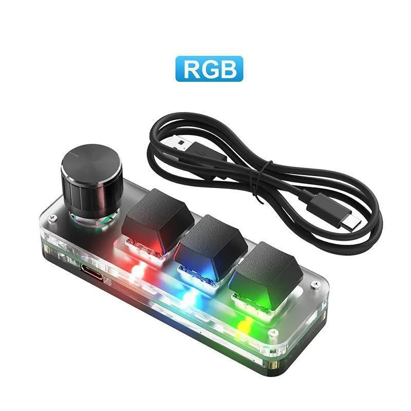 Compact black USB keypad with RGB colourful backlighting on a desk.