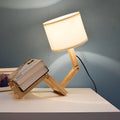 Creative small humanoid wooden table lamp with white fabric shade, 22x44x16cm, on bedside table
